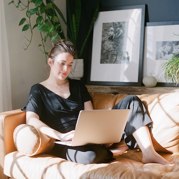 Vrouw op bank met laptop