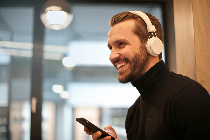 Man met telefoon en koptelefoon
